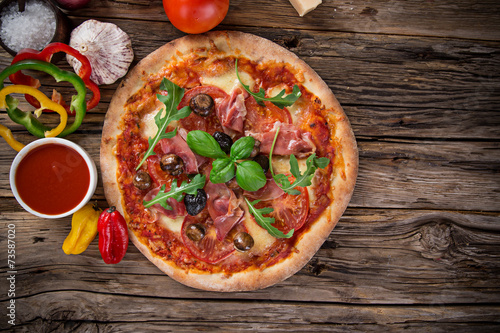 Delicious italian pizza served on wooden table #73587020