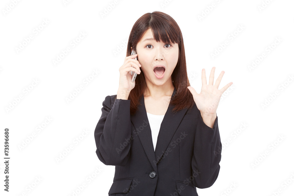 スマートフォンで通話しながら驚くビジネスウーマン スマートフォンで通話しながら驚くビジネスウーマン