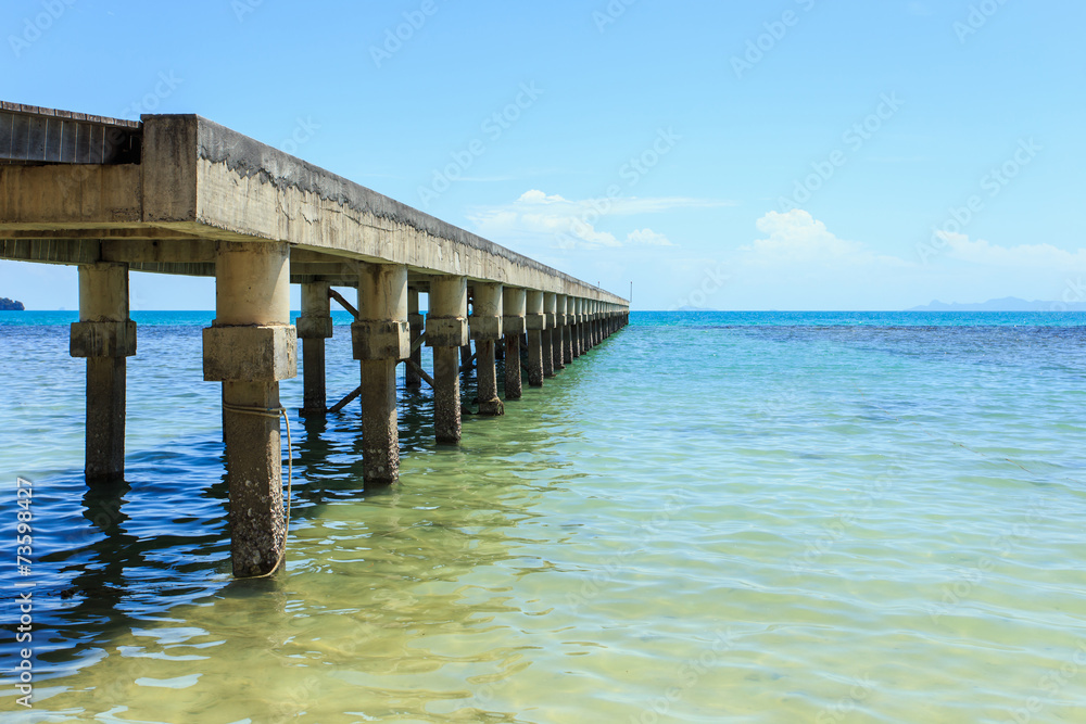A long concrete pier on the sea.