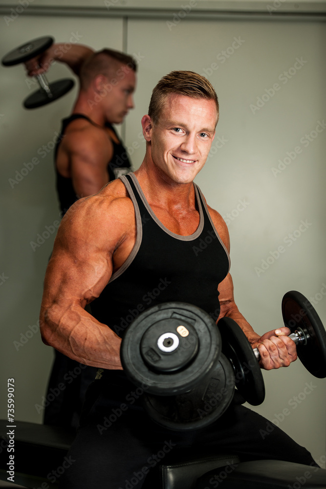 Hnadsome young man working out with dumbbells in fitness - powe Hnadsome young man working out with dumbbells in fitness - powe
