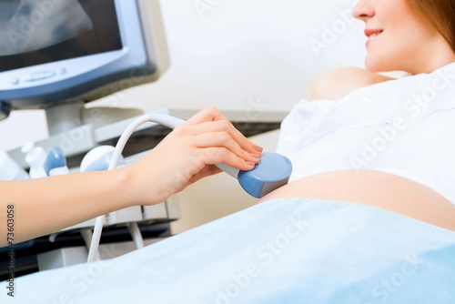close-up of hands and abdominal ultrasound scanner