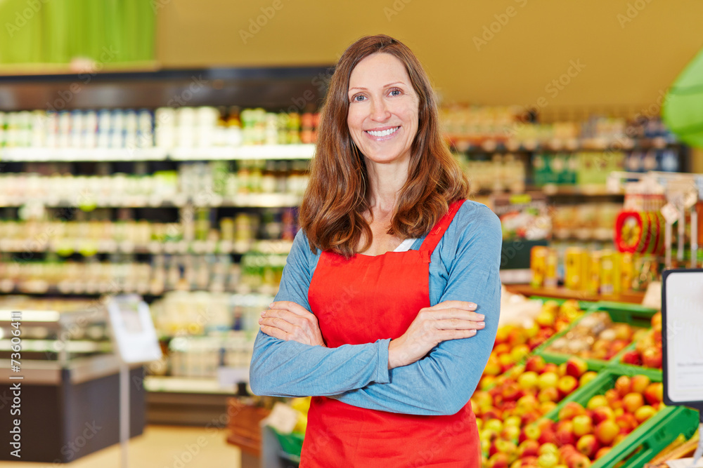 Lächelnde Marktleiterin steht im Supermarkt
