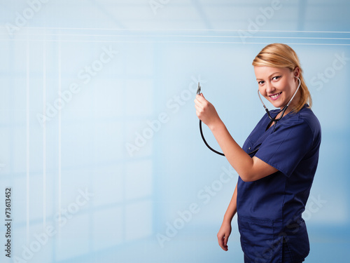 Pretty nurse in hospital listening to empty copy space with sthe photo