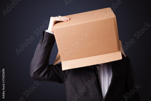 Businessman gesturing with a cardboard box on his head © ra2 studio
