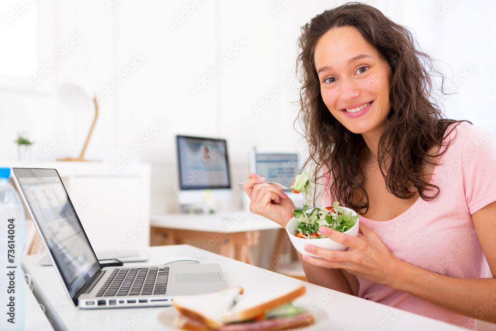 Young attractive student eating salad while working Young attractive student eating salad while working