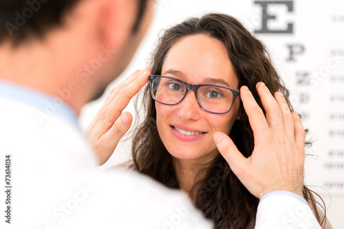 Fototapeta Naklejka Na Ścianę i Meble -  Young attractive woman trying glasses w optician