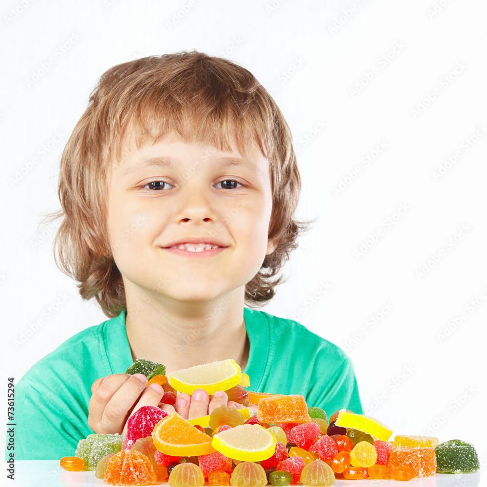 Little child with sweets and candies on a white background