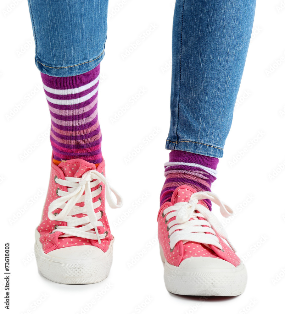 Female legs in colorful socks and sneakers isolated on white Female legs in colorful socks and sneakers isolated on white