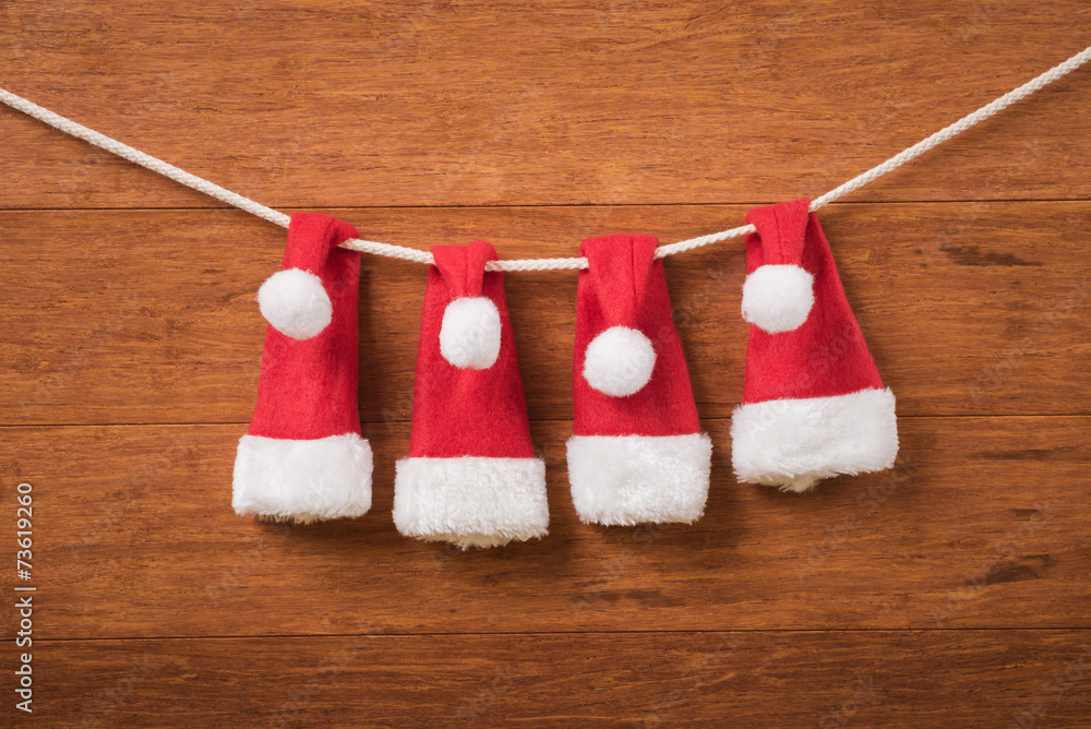 Santa hats on a rope on wooden background Santa hats on a rope on wooden background