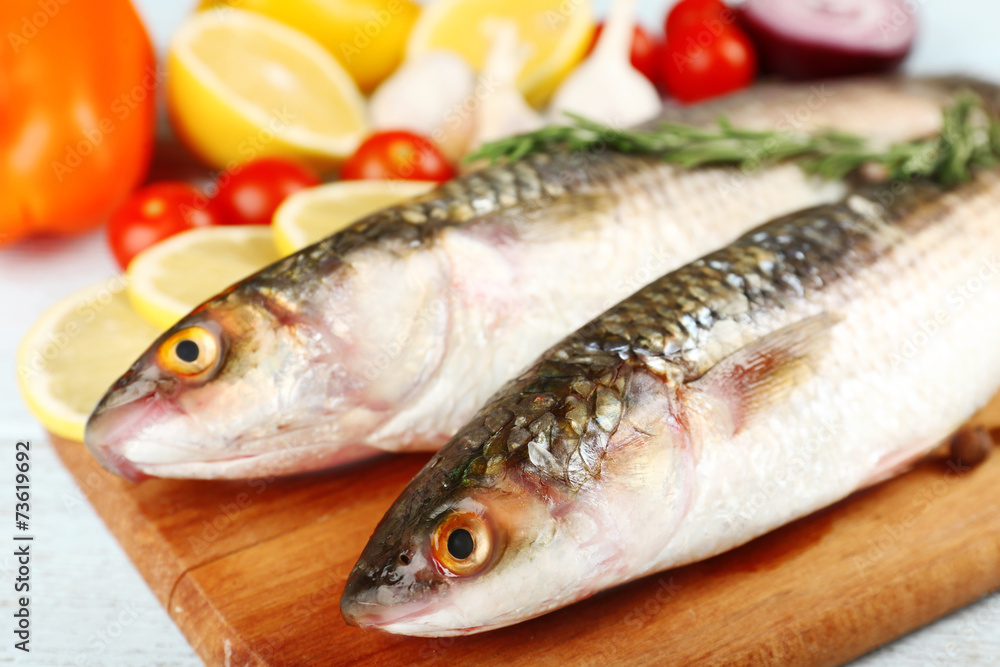 Fresh raw fish and food ingredients on table Fresh raw fish and food ingredients on table