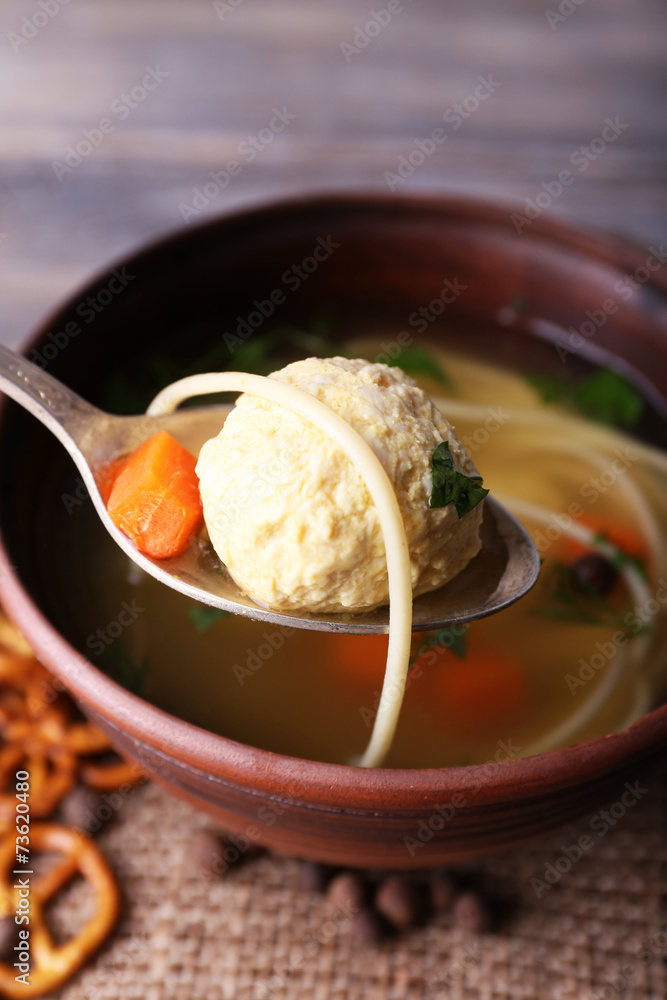 Meatball in spoon, close-up. Soup with meatballs and noodles in Meatball in spoon, close-up. Soup with meatballs and noodles in