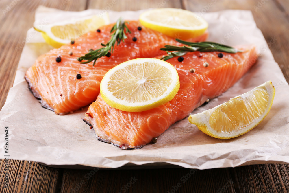 Fresh salmon with spices and lemon on wooden table