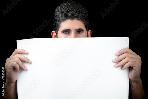 Young man hiding behind a white banner