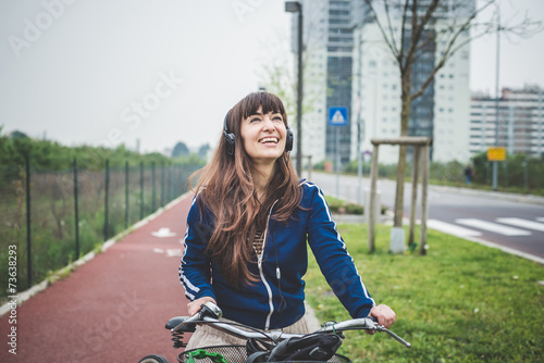 Smiling young woman riding bicycle on street in city