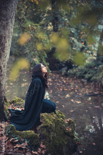 beautiful dark vampire woman with black mantle and hood