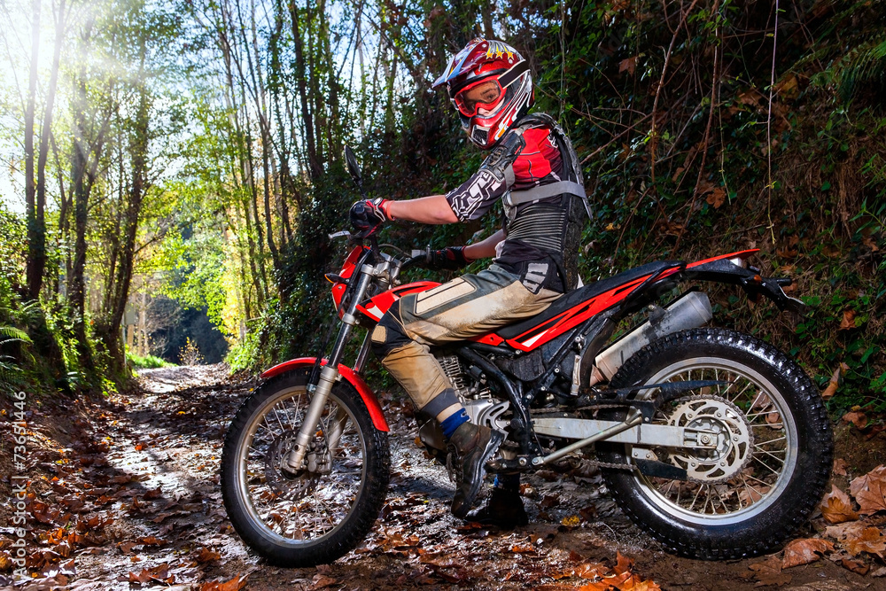 Naklejka premium Motocross rider with bike in dirt track.