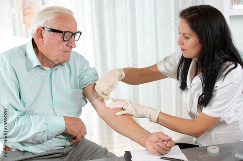 Valokuva Nurse with syringe is taking blood for test at the doctor office