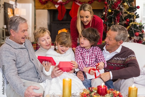 Multi generation family opening presents on sofa