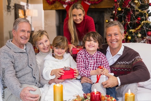 Multi generation family holding presents on sofa