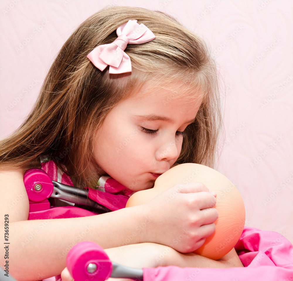 Cute little girl kissing her doll Cute little girl kissing her doll