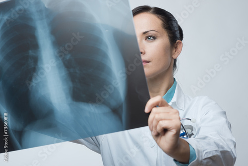 Foto Female doctor examining x-ray image