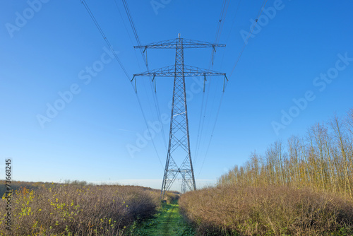 Transmission tower under a sunny sky at fall