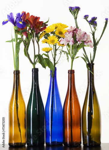 beautiful flowers in colorful bottles
