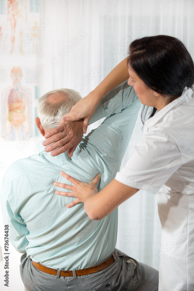 Chiropractic: Chiropractor examining senior man at office Chiropractic: Chiropractor examining senior man at office