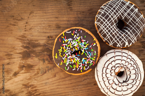 Bright donuts on wooden background