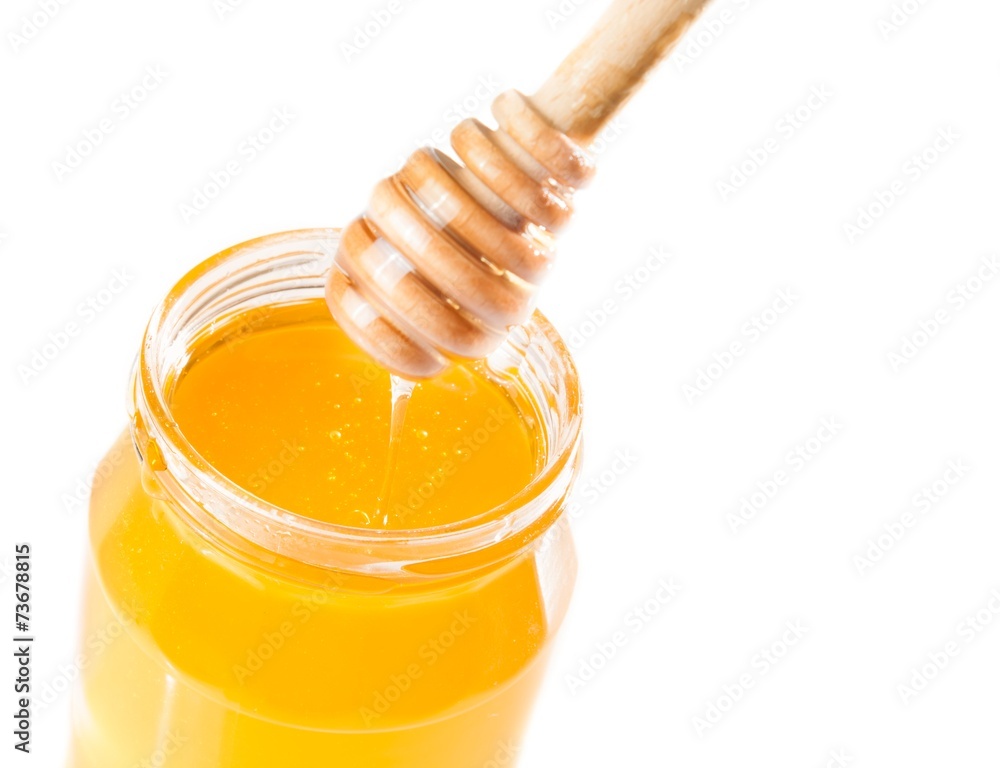 honey jar on white background with wooden honey dipper on top honey jar on white background with wooden honey dipper on top