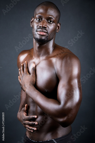 Beautiful and muscular man in dark background. © nenetus