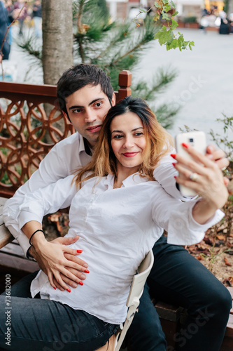 Young couple waiting baby, takes a Selfie in a bar © loreanto