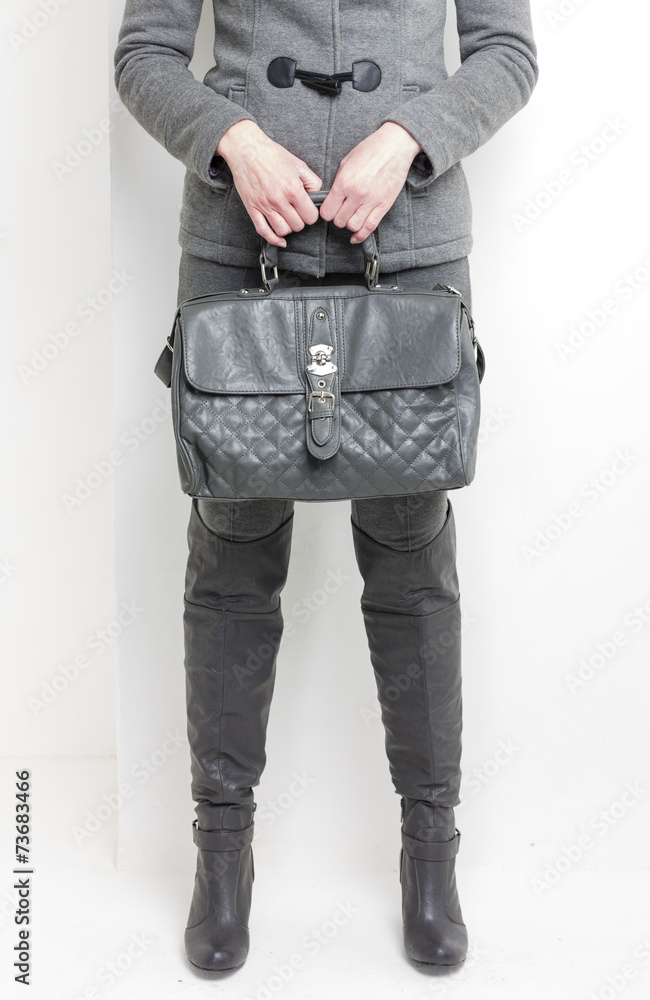 detail of standing woman wearing grey boots with a handbag detail of standing woman wearing grey boots with a handbag