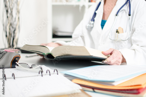 Female doctor reading a medical book