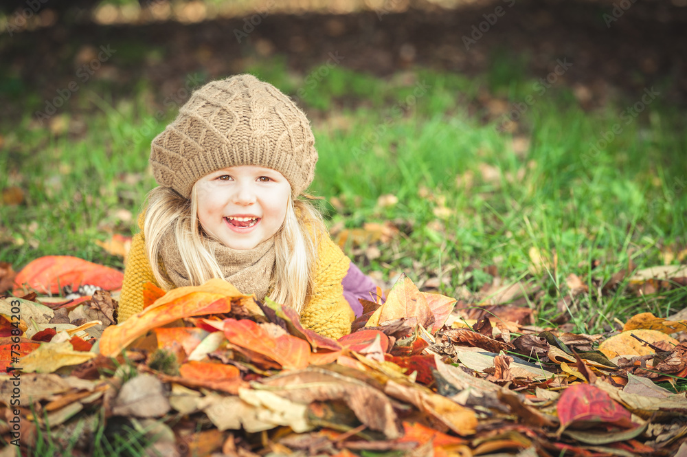 Beautiful girl, smiling blonde plays with the autumn leaves Beautiful girl, smiling blonde plays with the autumn leaves
