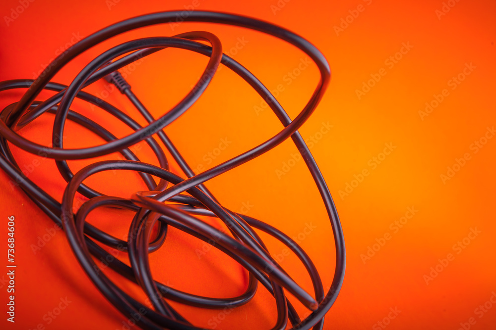 Abstract flexible audio cable on orange, nice music background Abstract flexible audio cable on orange, nice music background