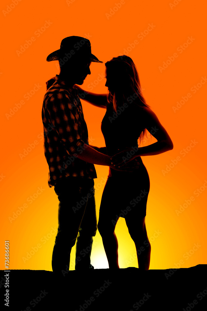 silhouette of a cowboy couple arms around each other