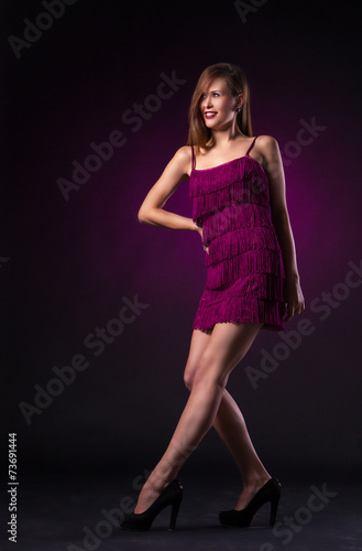 Beautiful woman in purple dress dancing