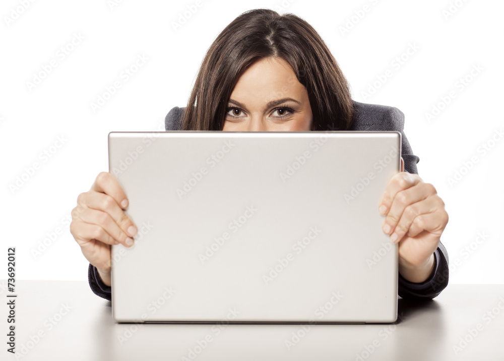 young happy beautiful businesswoman peek behind her laptop young happy beautiful businesswoman peek behind her laptop