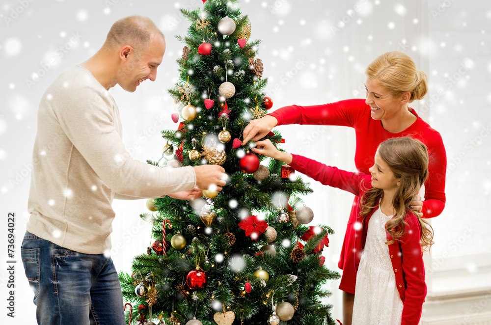 smiling family decorating christmas tree at home