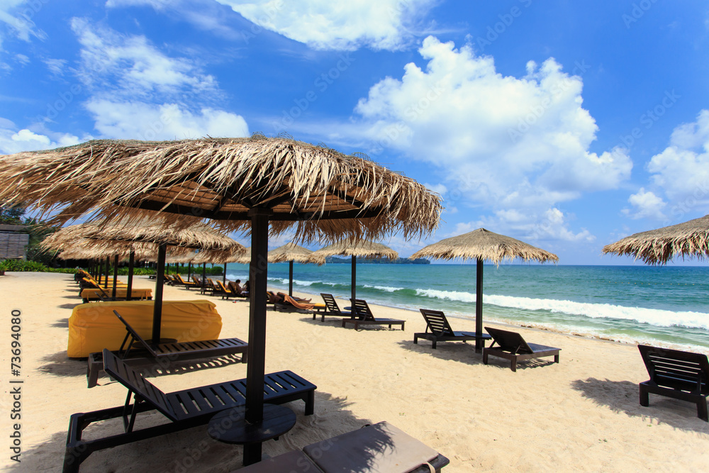 Sun umbrella and sun loungers stand at the beach in Phuket, Thai