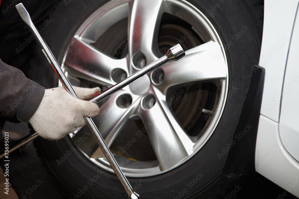 Fototapeta premium Car mechanic changing tire.