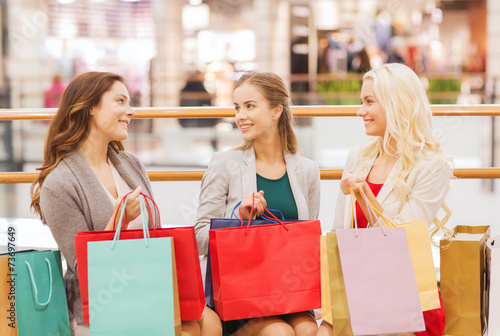 happy young women with shopping bags in mall