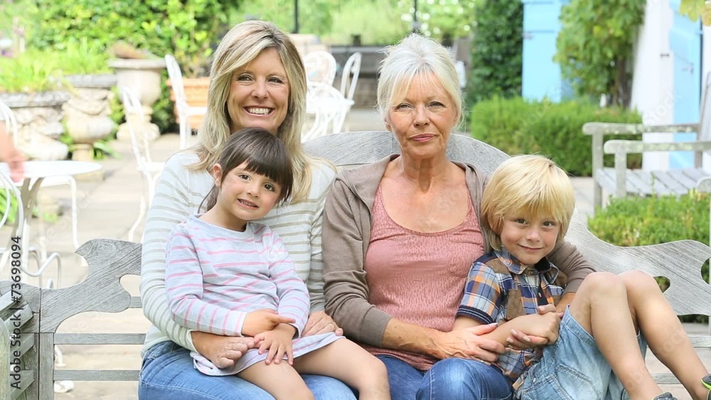 Woman with grandma and children sitting on bench Woman with grandma and children sitting on bench
