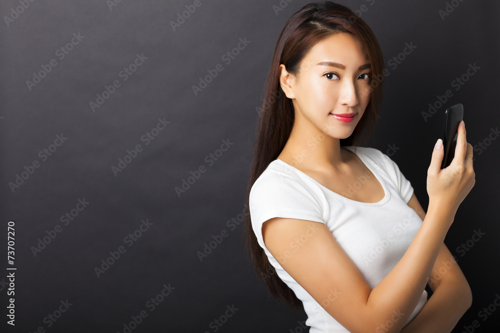 young woman holding smart phone with black background young woman holding smart phone with black background
