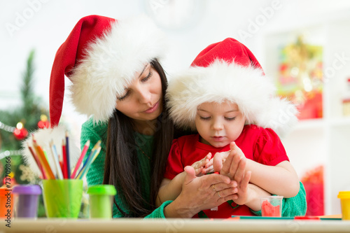 child and mom in Santa hats...