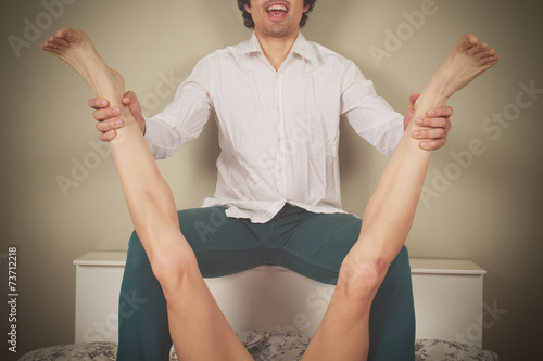 Happy man spreading legs of woman