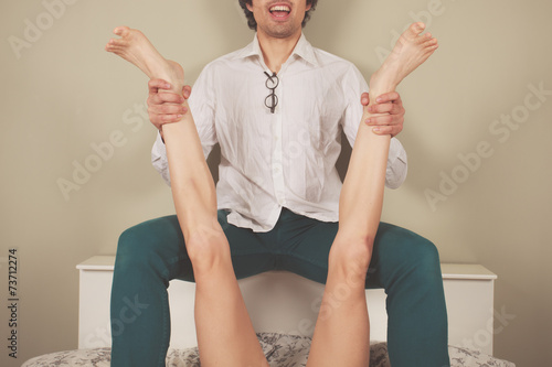 Happy man spreading legs of woman