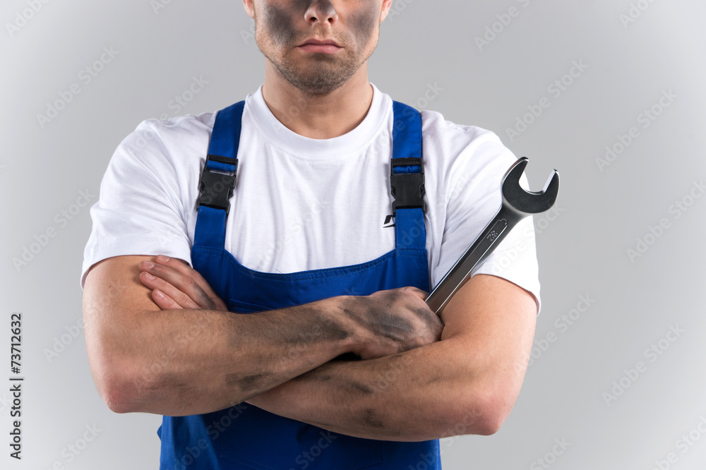 dity young mechanic in blue overall on blue background. dity young mechanic in blue overall on blue background.