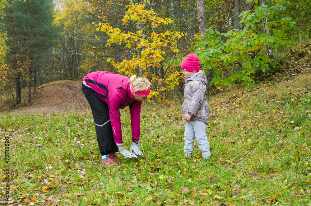Woman with girl doing aerobics in the autumn park Woman with girl doing aerobics in the autumn park